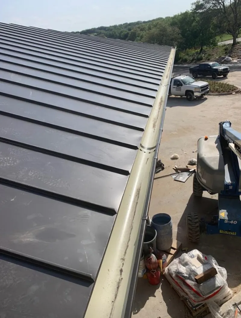 Standing seam panel and gutter detail on a metal roofing jobsite in Auburndale